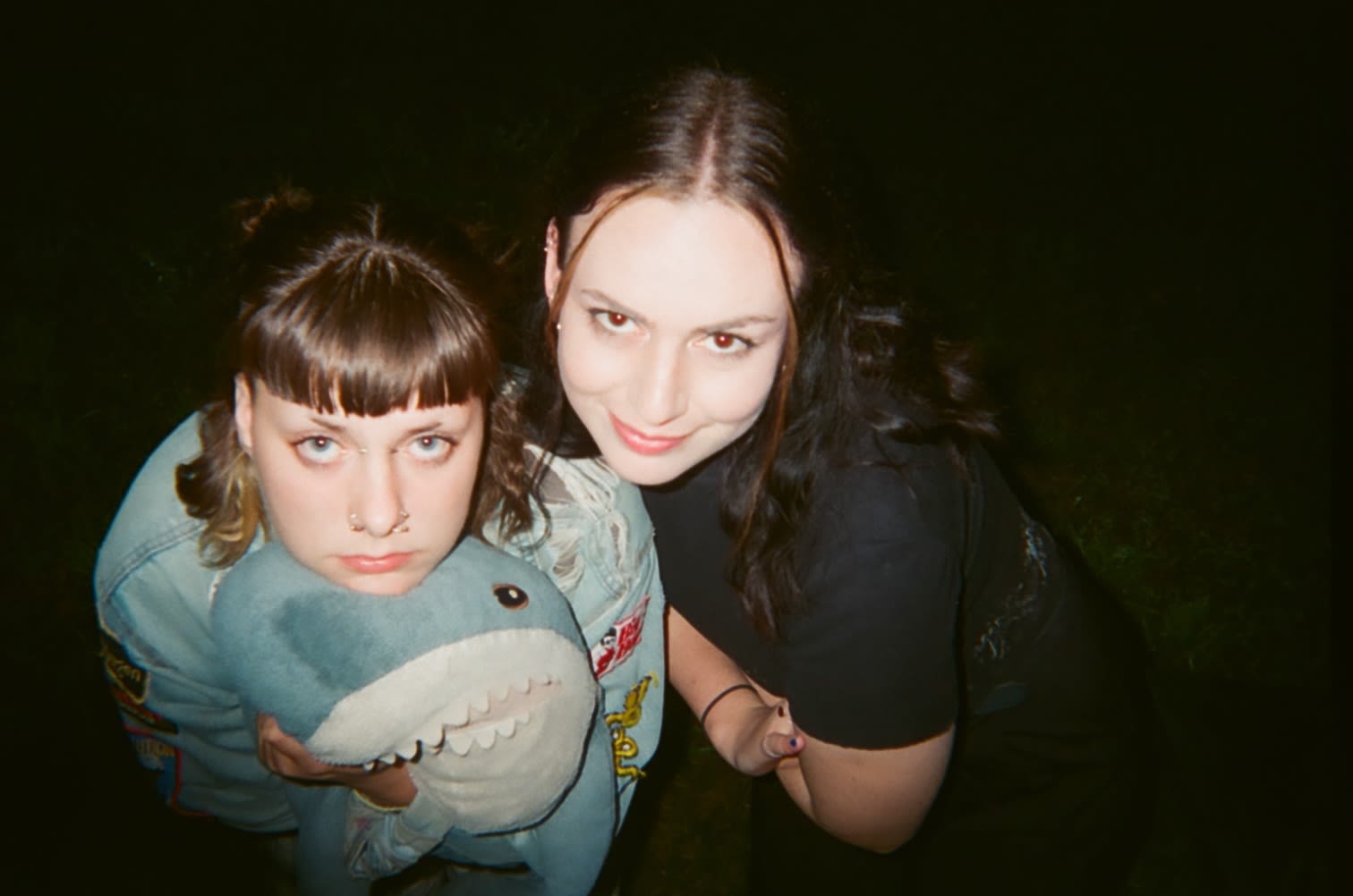 Eppie holds shark, Emma smiles into the camera