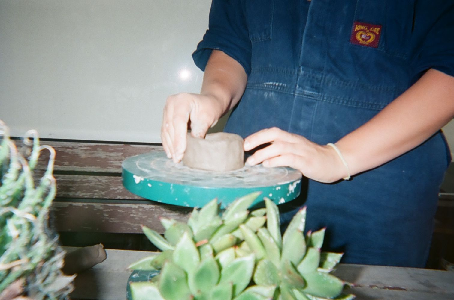 Eppie's hands can be seen creating pottery on a wheel